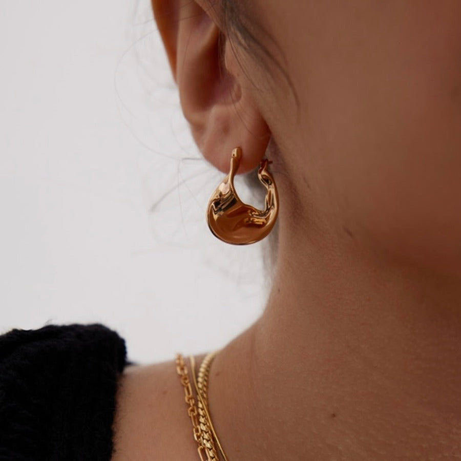 Crafted from 18k gold vermeil silver, the Astrid Curve Hoop Earrings feature a unique and eye-catching design, adding a touch of modern elegance to your everyday style.