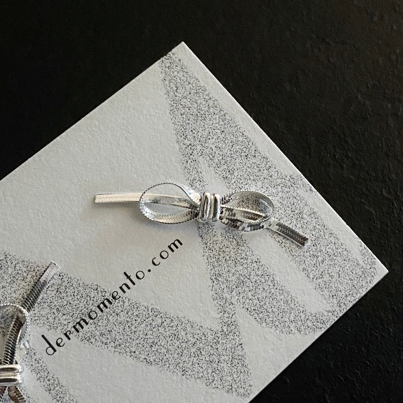 Amelia Ribbon Stud Earrings | dermomento.com – Bow-tie shaped stud earrings crafted from sterling silver flat snake chain material.