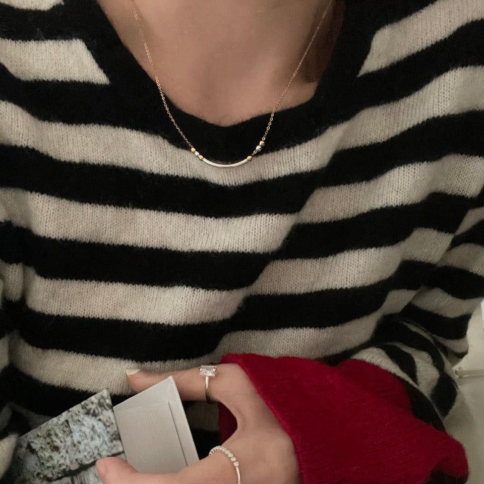 The smiley necklace combines sterling silver and 14-karat gold-filled chain and beads to create a special yet clean two-tone design.