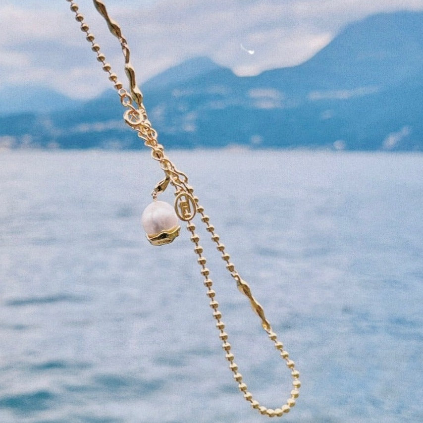 Baroque pearl pendant combined with claw-shaped irregular silver chain necklace, crafted in sterling silver with 18-karat gold vermeil finish.