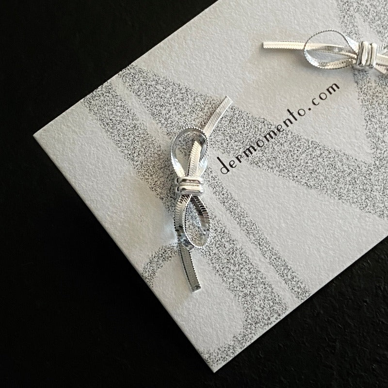 Amelia Ribbon Stud Earrings | dermomento.com – Bow-tie shaped stud earrings crafted from sterling silver flat snake chain material.
