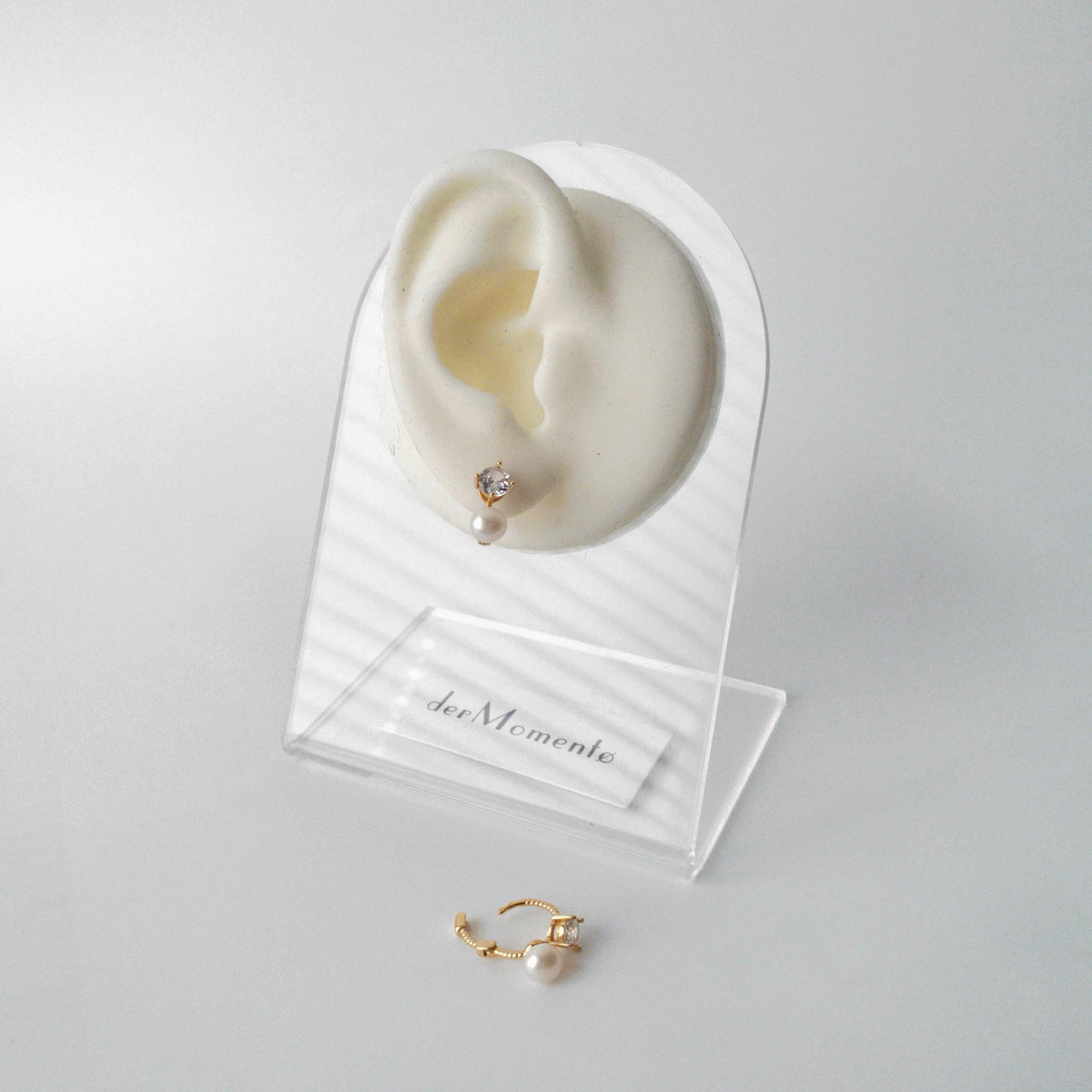 ENJA small pearl hoop earrings worn on ear stand
