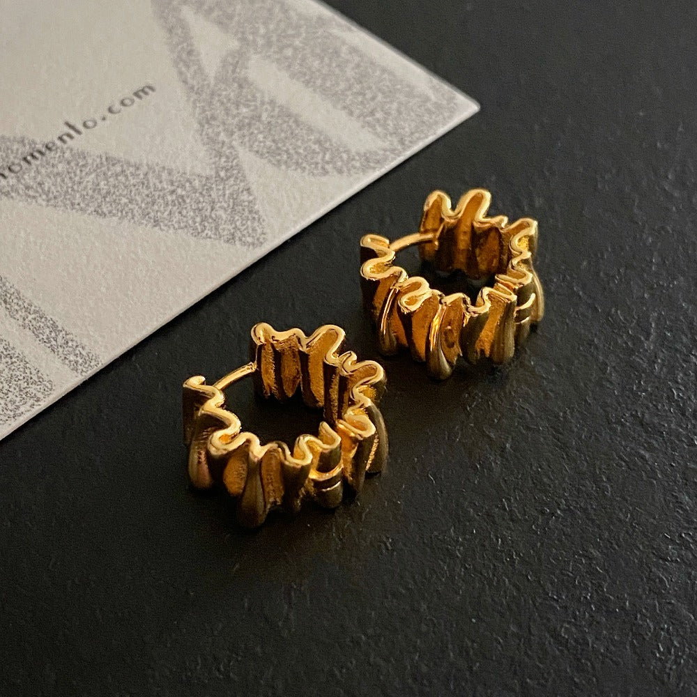 A close-up of Anastasia Foil Pleat Hoop Earrings | dermomento.com - Crafted from 18-karat gold vermeil silver with a unique design with foil-like pleats.