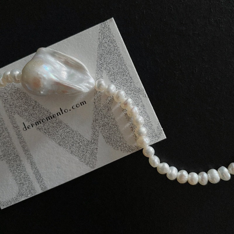 The Greta Pearl necklace is a stunning piece inspired by nature forms. Made with a large baroque pearl along with smaller freshwater pearls, all held together by a sterling silver clasp. The versatile design makes it suitable for all seasons, making it a must-have accessory for any fashion-forward individual.