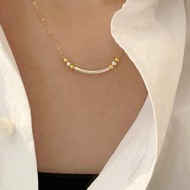 The smiley necklace combines sterling silver and 14-karat gold-filled chain and beads to create a special yet clean two-tone design.