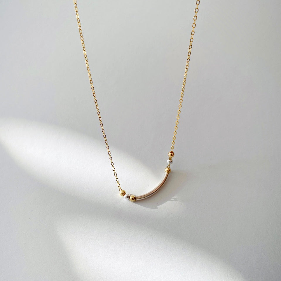The smiley necklace combines sterling silver and 14-karat gold-filled chain and beads to create a special yet clean two-tone design.