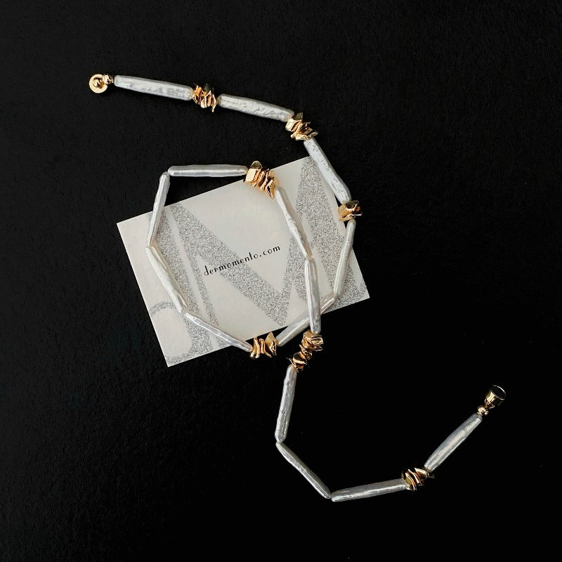 The Clara Baroque Pearl Necklace features a unique, non-uniform shape of stick baroque pearls, accentuated by a magnetic clasp and irregularly placed 14K gold-plated brass details.
