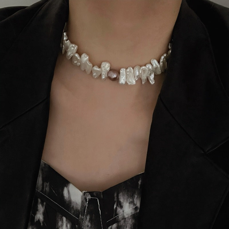 Model wearing a cream biwa baroque pearl choker necklace with a uniquely coloured baroque pearl in the centre.