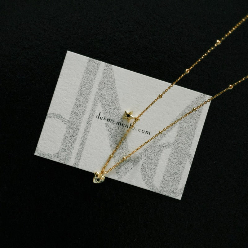 Starry Heart Necklaces featuring a heart and star design pendant, crafted from 18k gold vermeil sterling silver and adorned with sparkling small black zirconia stone.