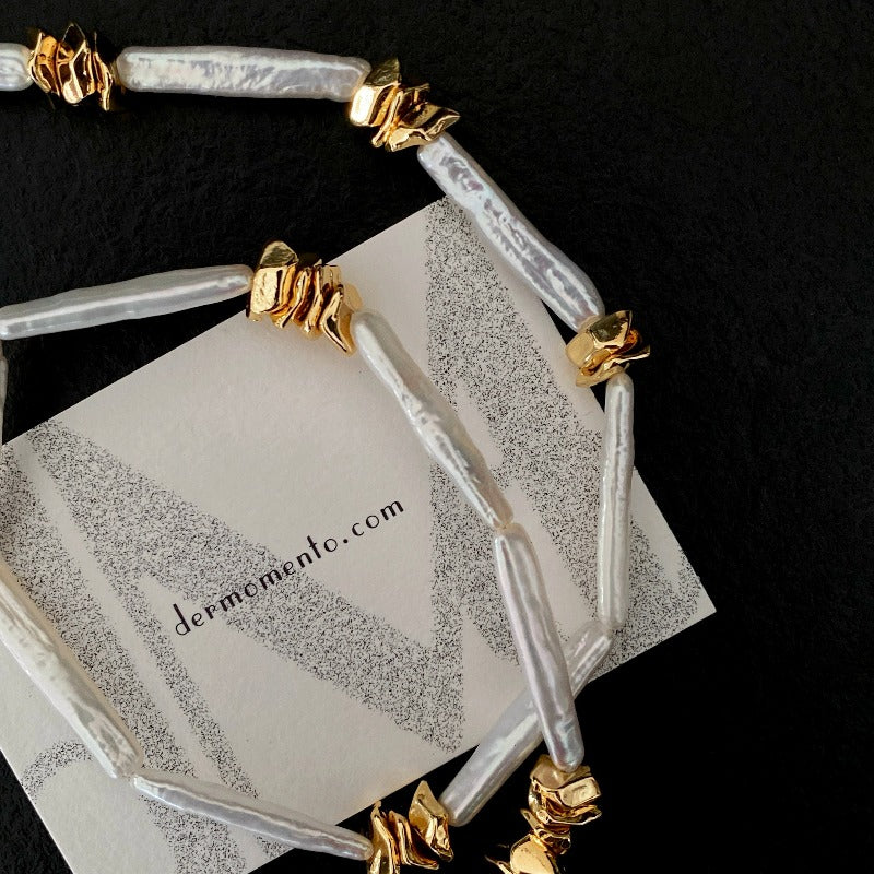 The Clara Baroque Pearl Necklace features a unique, non-uniform shape of stick baroque pearls, accentuated by a magnetic clasp and irregularly placed 14K gold-plated brass details.