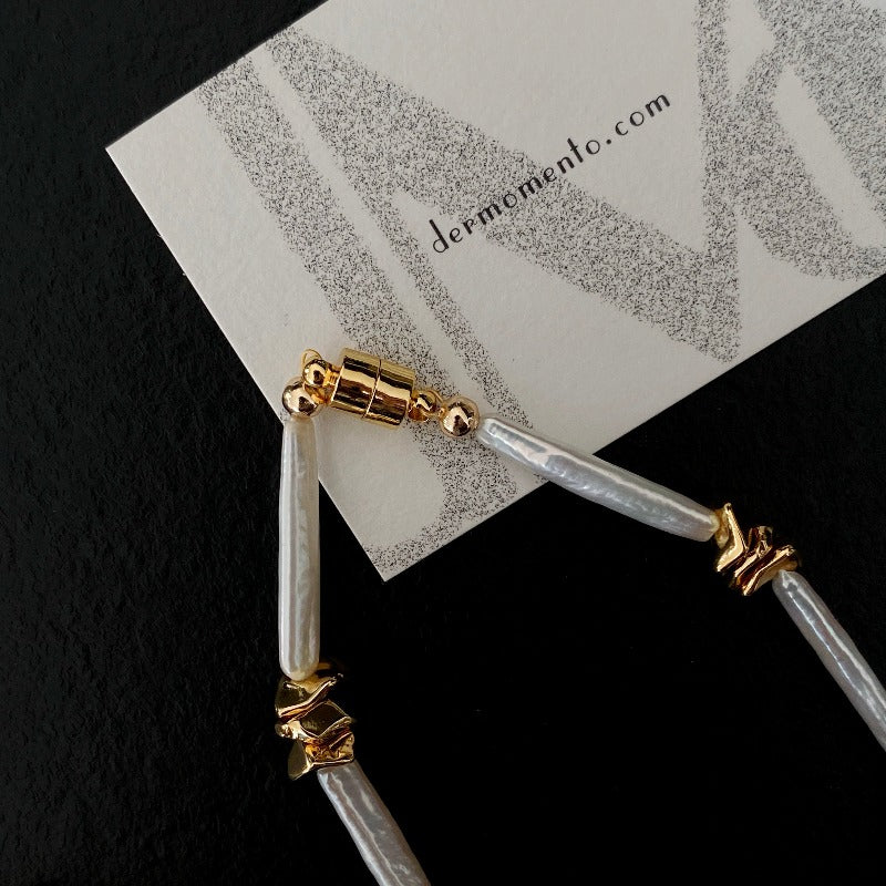 The Clara Baroque Pearl Necklace features a unique, non-uniform shape of stick baroque pearls, accentuated by a magnetic clasp and irregularly placed 14K gold-plated brass details.