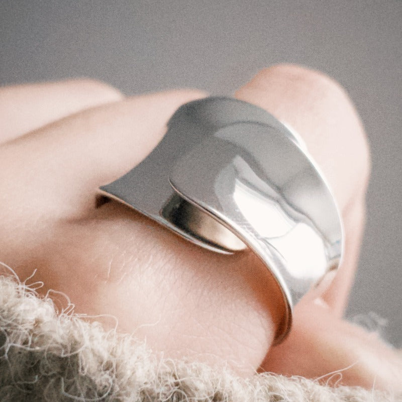 Bold ring crafted from white rhodium-plated silver with an eye-catching wide cross-cut band and a concave-shaped open design.