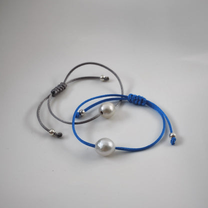 2 pieces of handmade single pearl silk cord string bracelets featuring a single natural baroque oval pearl with a stunning silver-blue lustre , delicately strung on adjustable silk cord in blue and grey and adorned with silver beads.