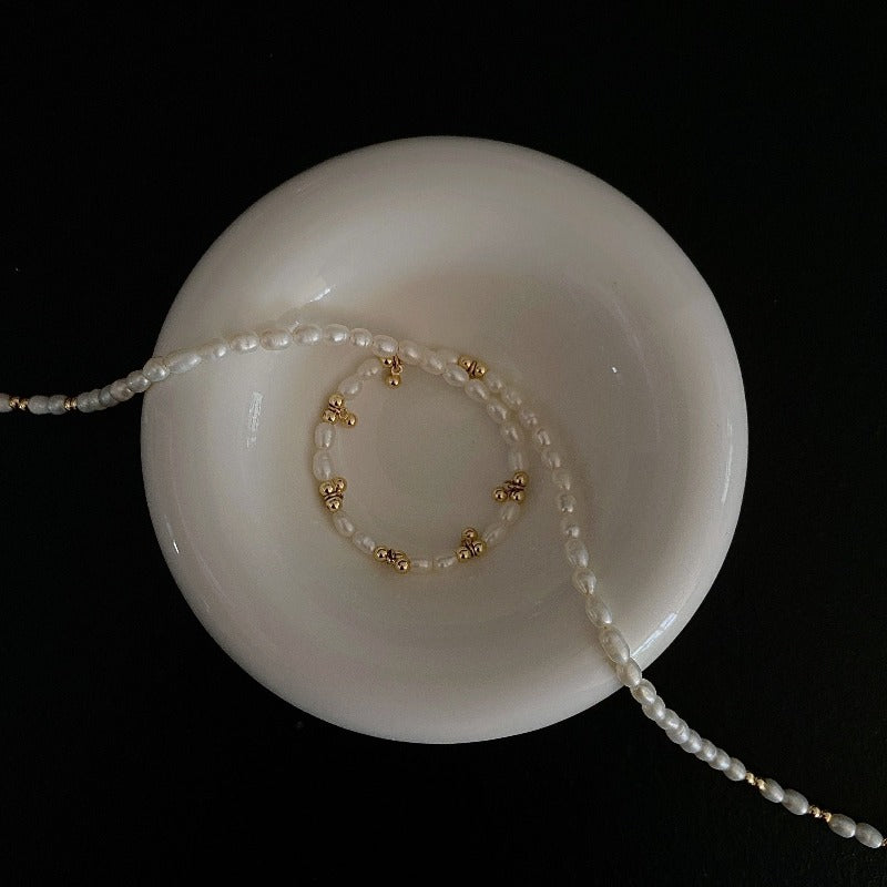 Showcasing the Livia Beaded Necklace crafted from natural freshwater pearl and sprinkled with 14k gold-plated beads. 