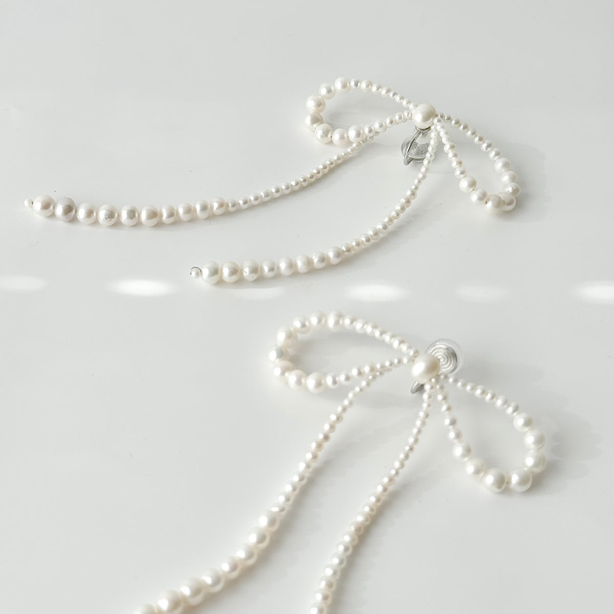 Close-up of graduated freshwater pearls forming oversized bow-shaped loops