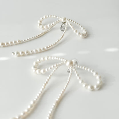 Silver-tone clip-on fastening on handmade pearl bow earrings