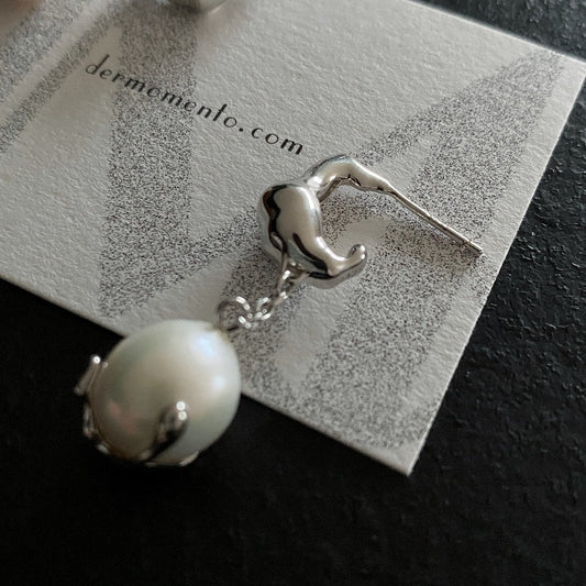 Baroque pearl drop earrings with claw form in sterling silver crafted with a white rhodium-plated finish.