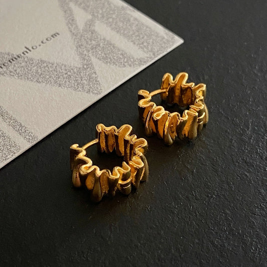 A close-up of Anastasia Foil Pleat Hoop Earrings | dermomento.com - Crafted from 18-karat gold vermeil silver with a unique design with foil-like pleats.