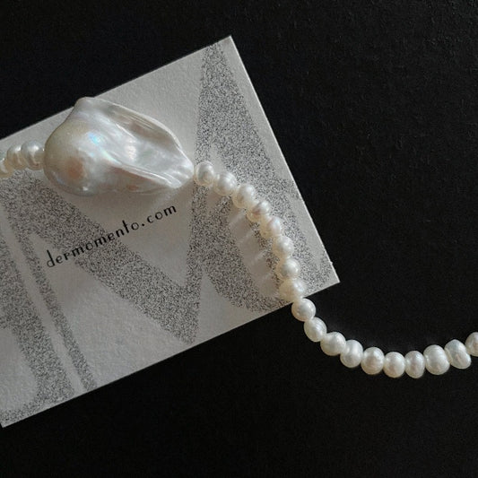 The Greta Pearl necklace is a stunning piece inspired by nature forms. Made with a large baroque pearl along with smaller freshwater pearls, all held together by a sterling silver clasp. The versatile design makes it suitable for all seasons, making it a must-have accessory for any fashion-forward individual.