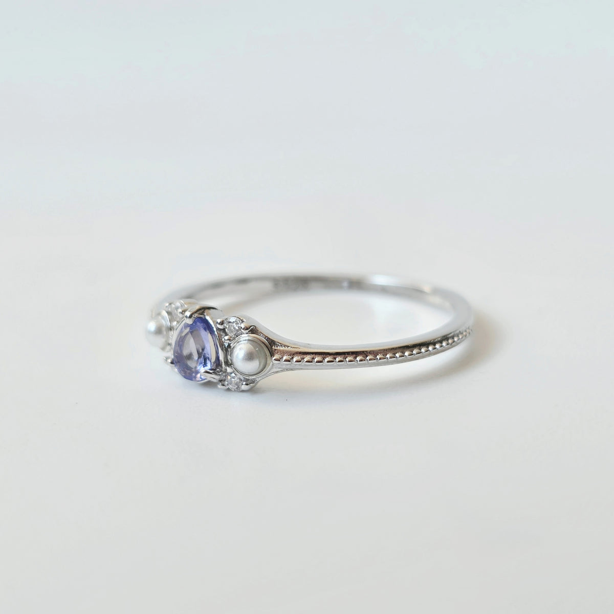 Close-up of sterling silver ring with natural tanzanite and cubic zirconia setting