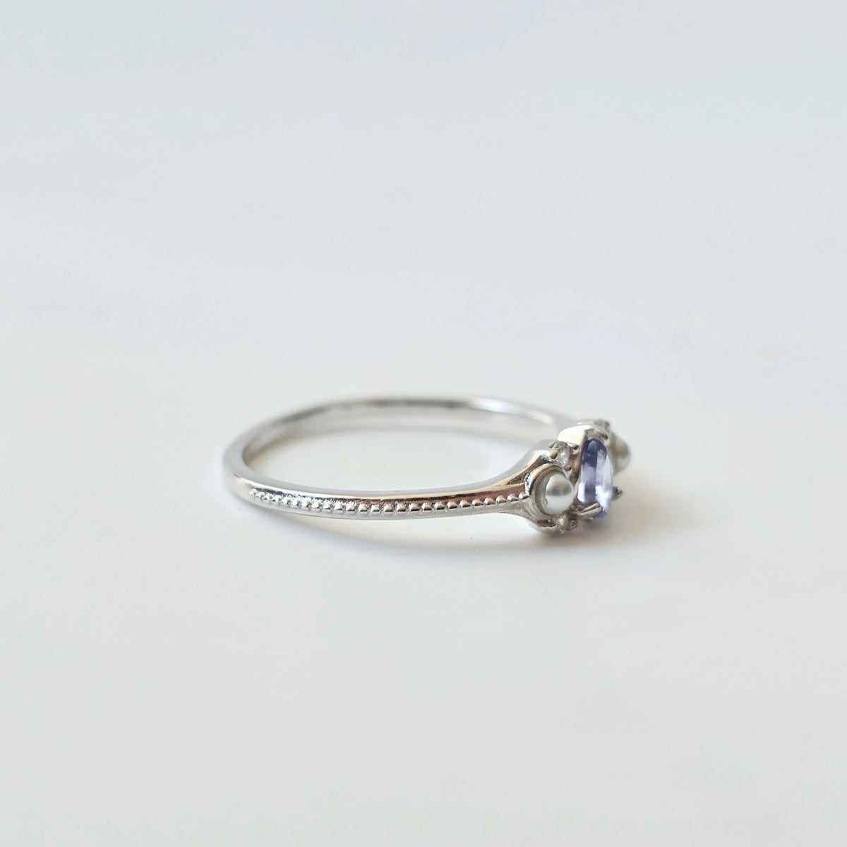 Side view of LINNIE tanzanite ring showing slim silver band and gemstone setting