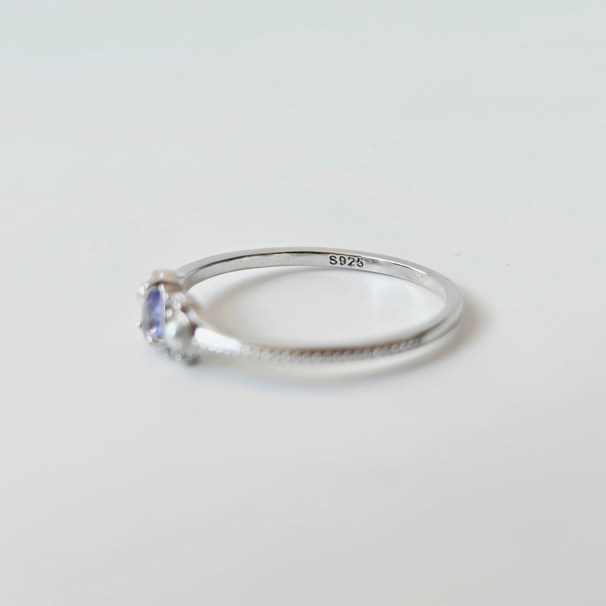 Side view of LINNIE tanzanite ring showing slim silver band and gemstone setting with S925 stamp