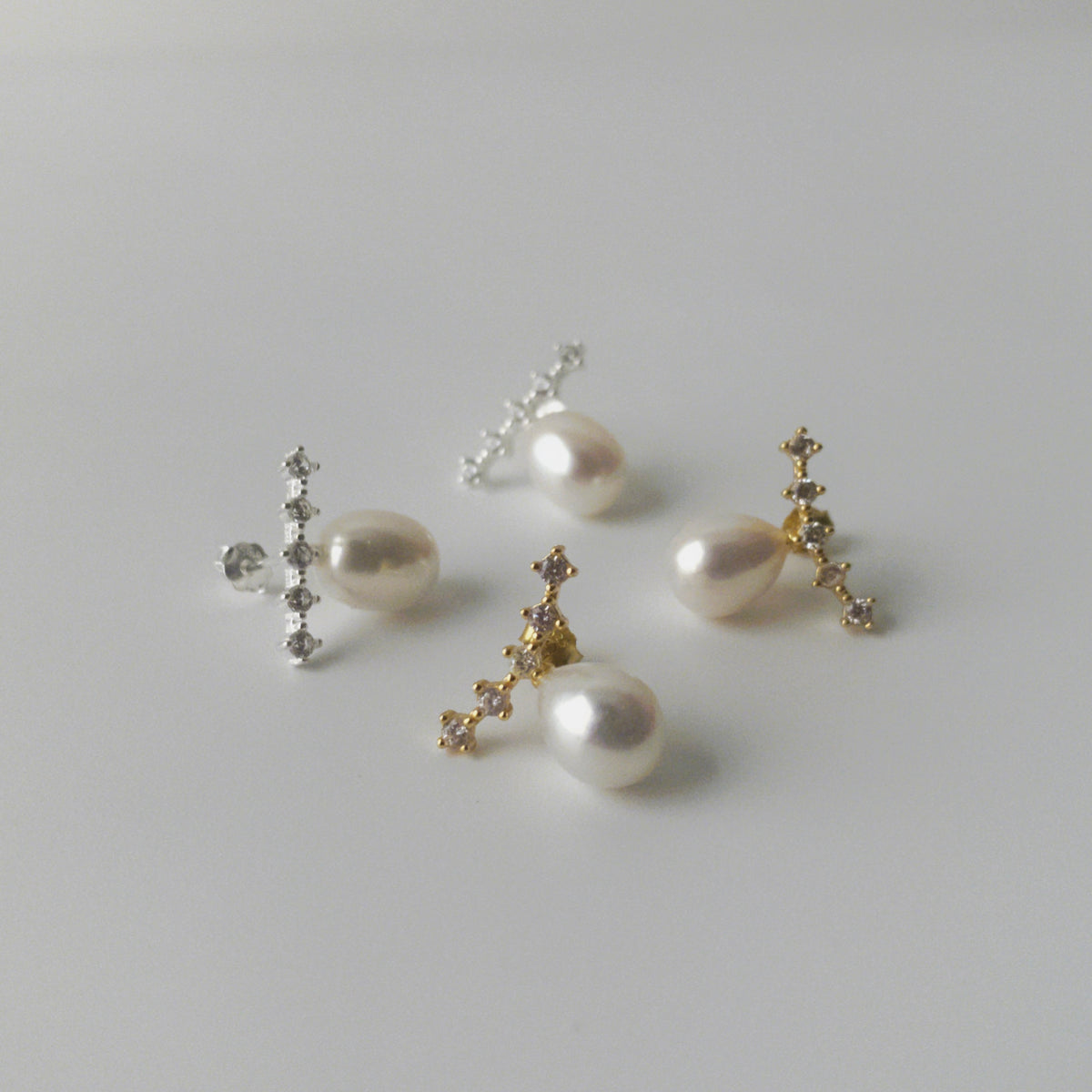 Close up of LYNN pearl stud earrings with oval pearls and angled zirconia rows