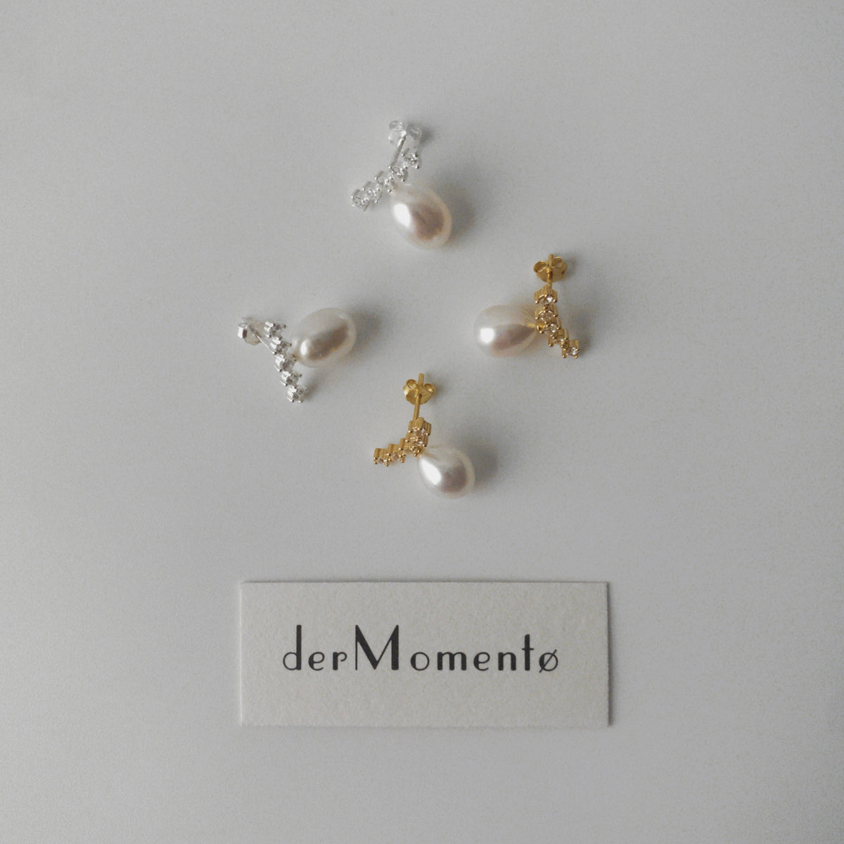 Pair of LYNN pearl stud earrings with oval pearls and angled zirconia rows