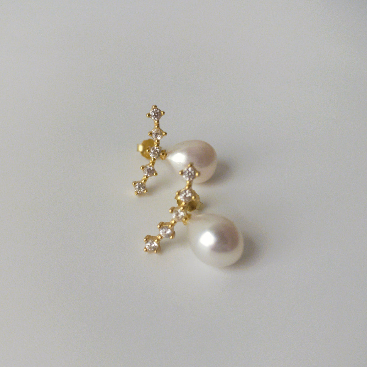 LYNN gold vermeil pearl stud earrings with asymmetrical zirconia settings