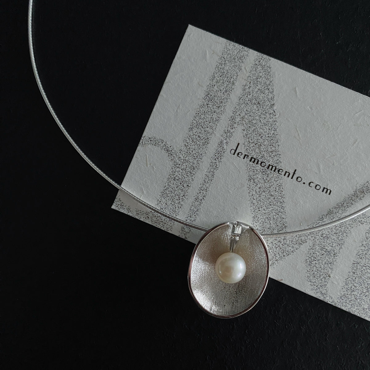 Close-up of sterling silver seashell pendant with natural freshwater pearl