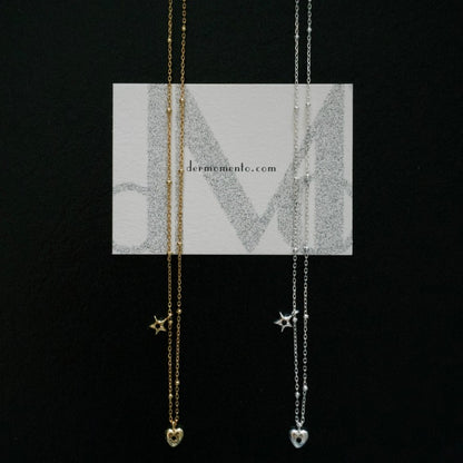 Close-up of petite heart and star pendant with black zirconia