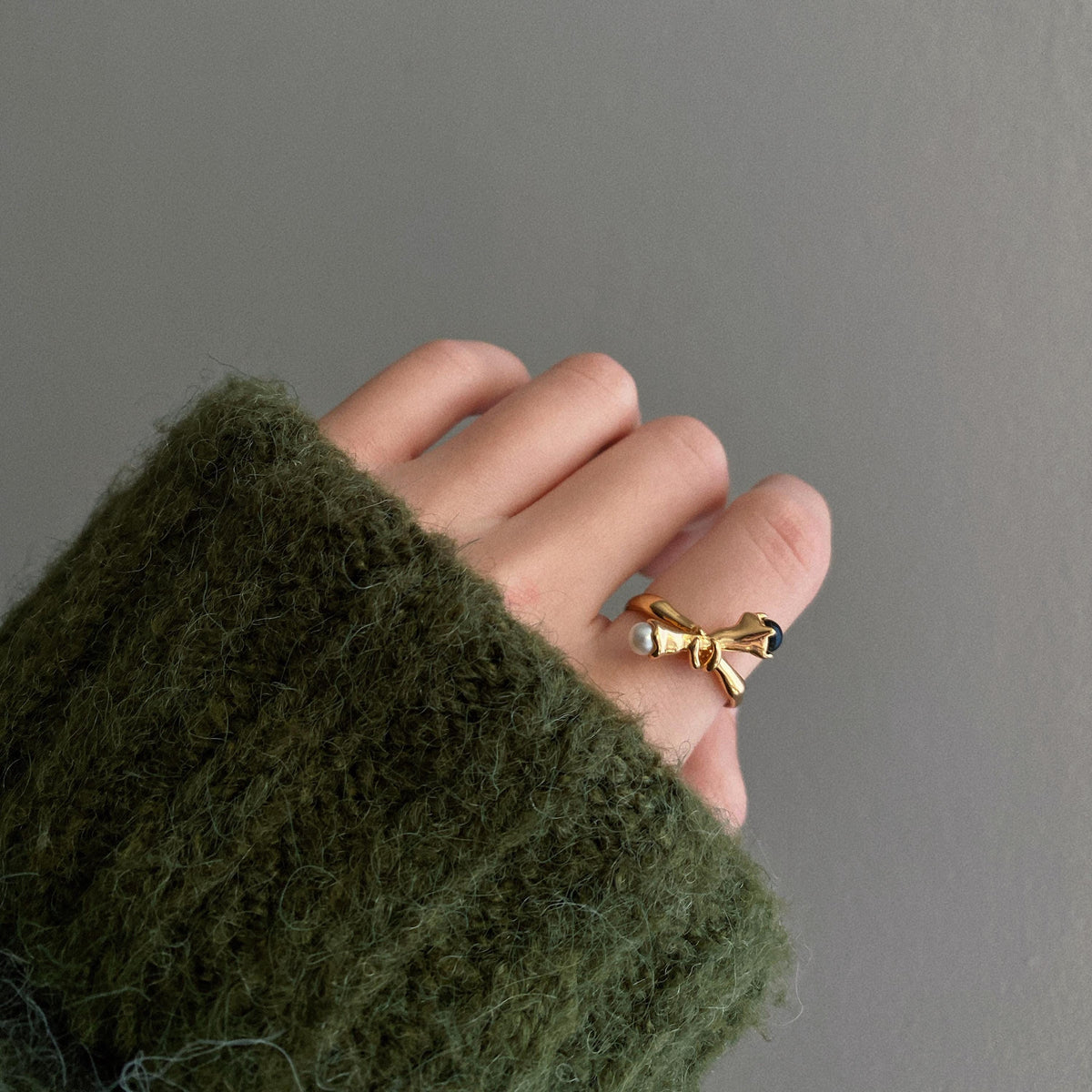 Asymmetrical pearl and black onyx open ring worn on hand