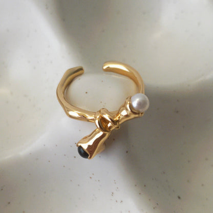 Adjustable pearl and black onyx ring with overlapping knotted band