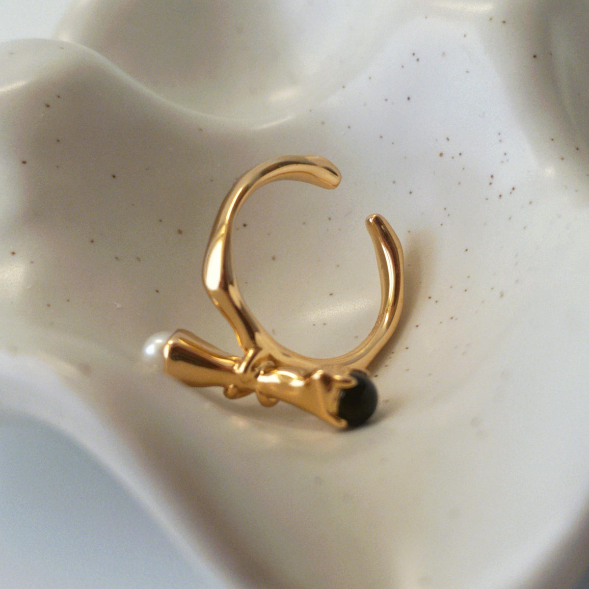 Side view of branch-like sterling silver ring with pearl and onyx