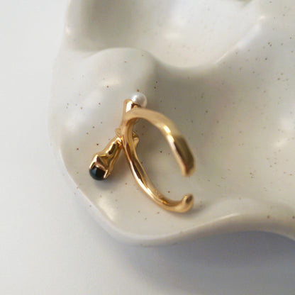 Close-up of sculptural open ring with intertwined metal curves