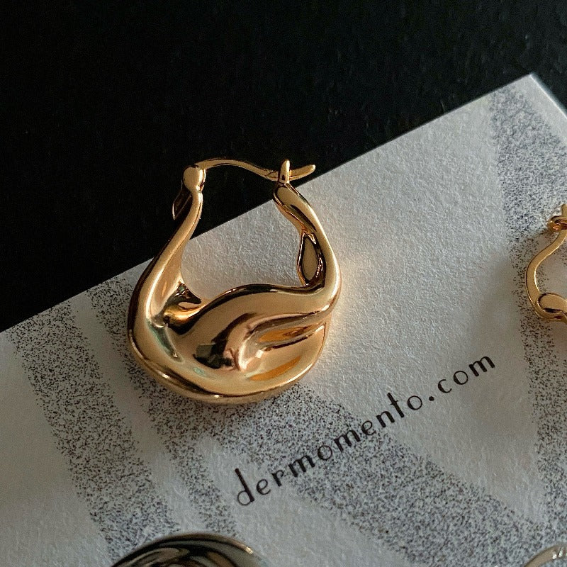 Close-up of ASTRID gold vermeil hoops with polished curved surfaces