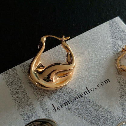 Close-up of ASTRID gold vermeil hoops with polished curved surfaces