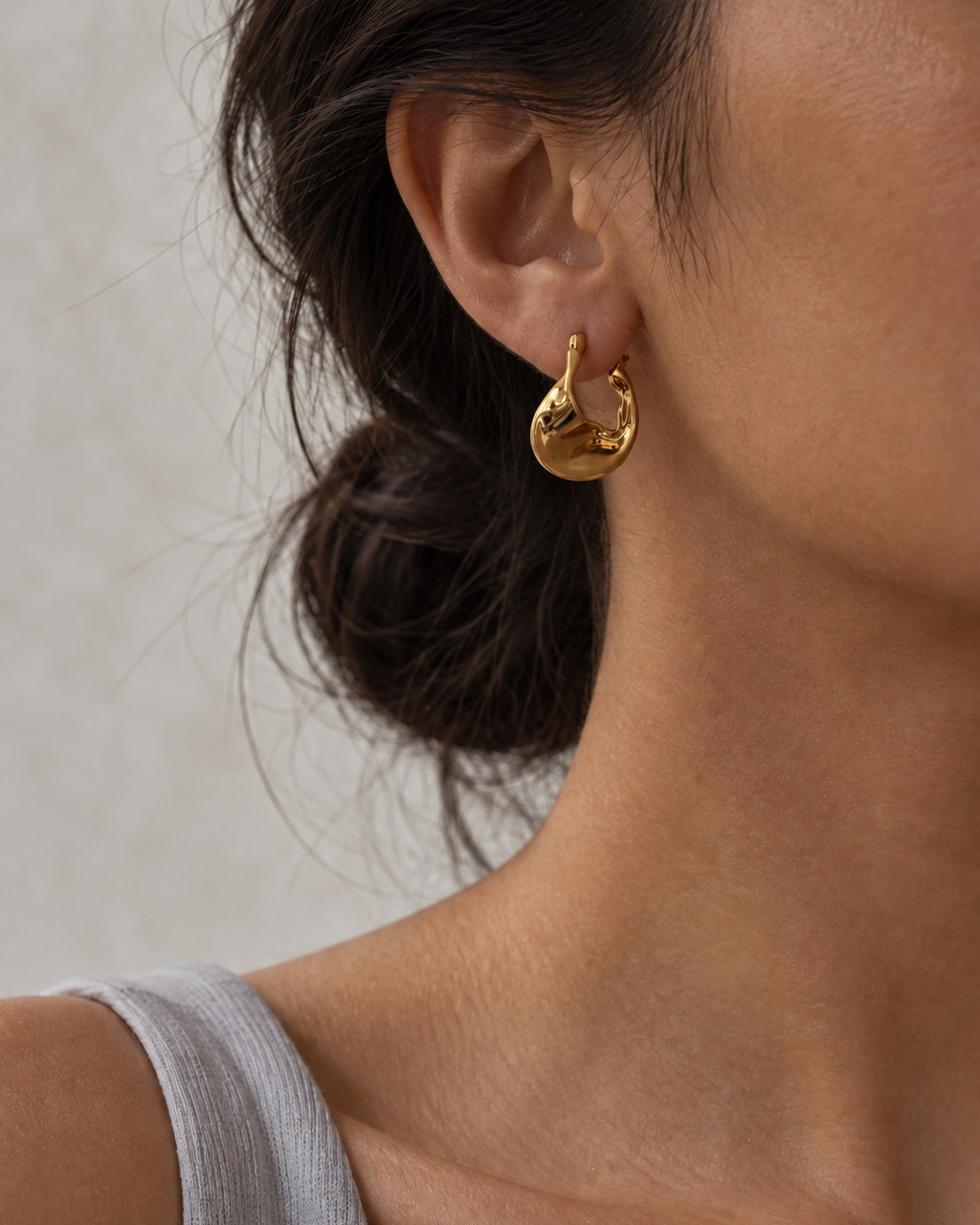 ASTRID sculptural gold hoop earrings worn on ear