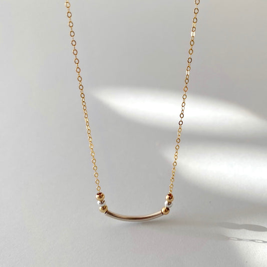 The smiley necklace combines sterling silver and 14-karat gold-filled chain and beads to create a special yet clean two-tone design.