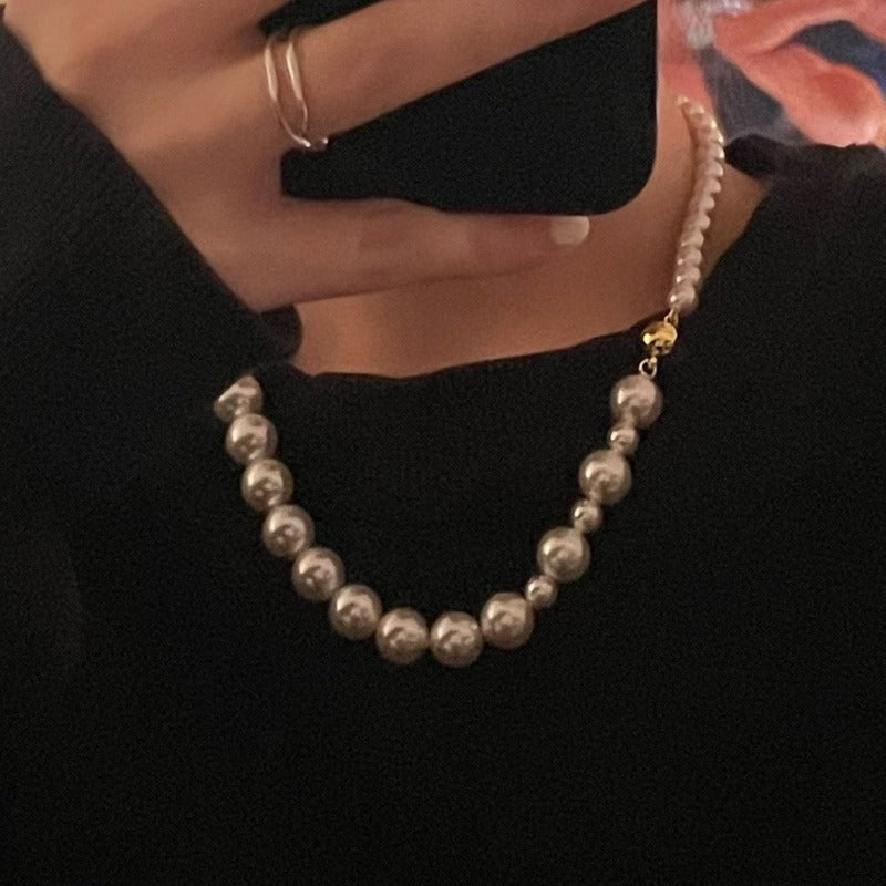 Model wearing the Mira Crystal Pearl Necklace combines crystal pearls in a delightful gradient arrangement, accented with a golden magnetic clasp. 