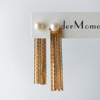 Close-up of THEA freshwater pearl stud earrings with long gold vermeil chain tassels