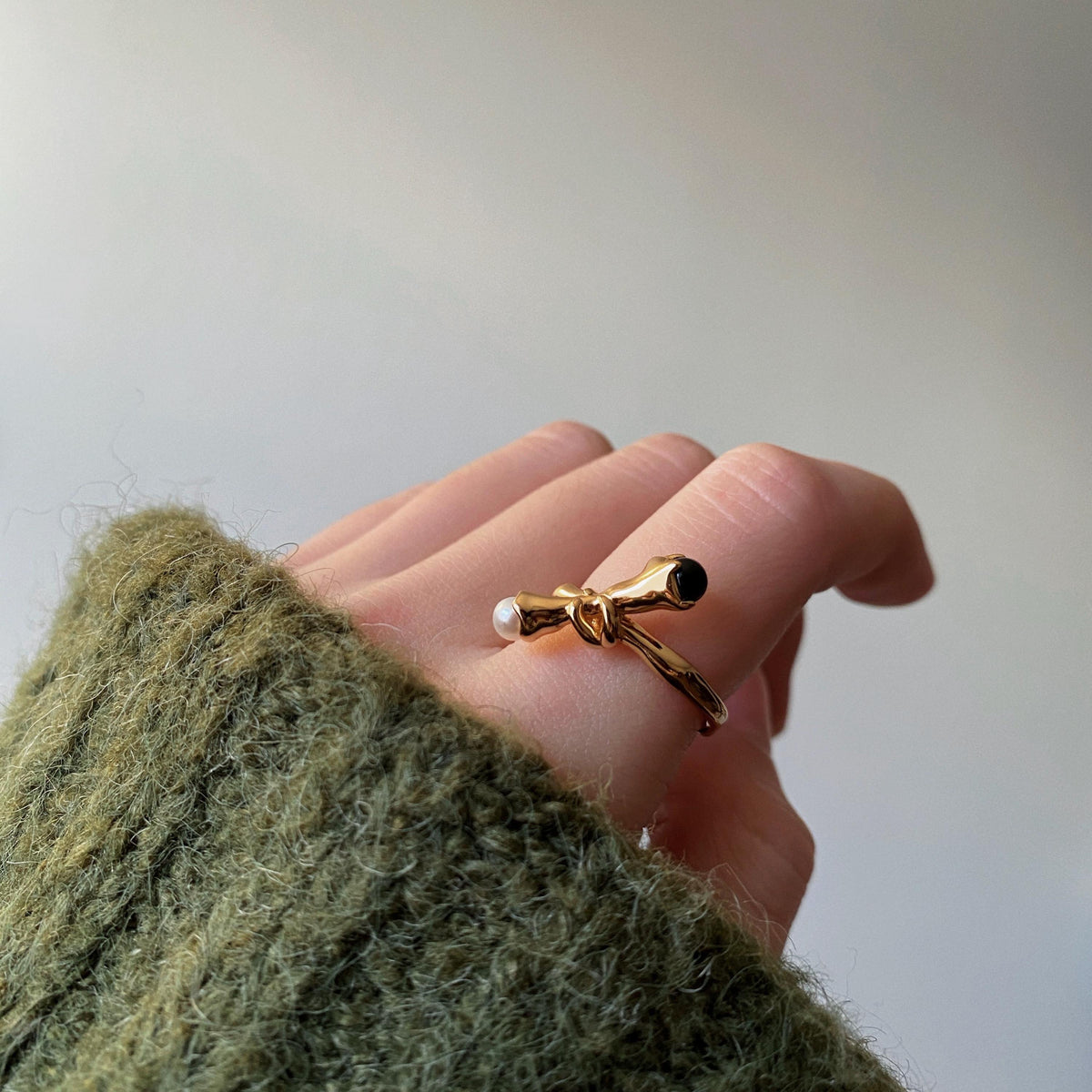 Natural freshwater pearl and polished black onyx on gold vermeil ring worn on hand